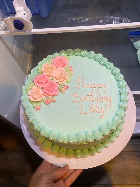 Mint green birthday cake decorated with pink flowers