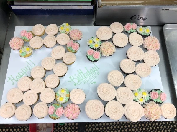 Floral cupcakes arranged around a birthday message